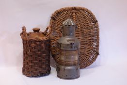 Painted metal Anker light, wicker basket lid and a stoneware bottle in wicker case,