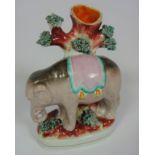 Victorian Staffordshire spill vase in the form of an elephant standing in front of a tree trunk,