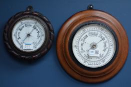 Early 20th century circular aneroid barometer set on oak surround,