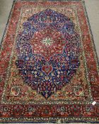 Persian Kashan hand knotted red and blue ground rug, overall floral decoration,