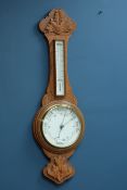 Early 20th century aneroid barometer with thermometer in carved light oak case,