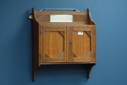 Edwardian oak two door cupboard with bevelled mirror,