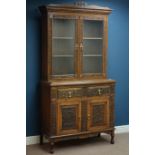 Late 19th century heavily carved oak dresser with raised bookcase enclosed by two glazed doors,