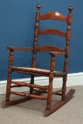 20th century stained beech framed ladder back rocking chair with cane seat Condition