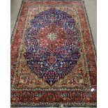 Persian Kashan hand knotted red and blue ground rug, overall floral decoration,