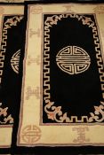 Pair of black ground Chinese washed woollen shou motif rugs 154cm x 92cm (2)