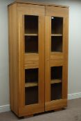 Light oak bookcase enclosed by two glazed doors, W101cm, H196cm,