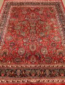 Persian Kashan red ground rug, blue border with floral patterns,