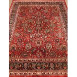 Persian Kashan red ground rug, blue border with floral patterns,