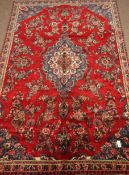 Persian Hamadan, red ground with floral decoration, central blue medallion,