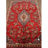 Persian Hamadan, red ground with floral decoration, central blue medallion,