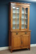 Arts and Crafts period oak glazed bookcase on cupboard, two panelled doors and single drawer,