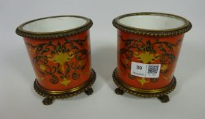 Pair of early 20th Century continental porcelain pots with gilt metal mounts and supported by four