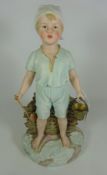 19th/ early 20th Century painted bisque figure of a boy with bucket and spade and beach attire