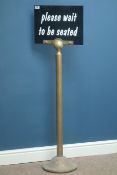 'Please wait to be seated' sign on brass pedestal,