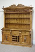 Large carved pine dresser, three drawers and two cupboards with wine rack to centre,