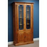 Pine bookcase enclosed by two blue tinted lead glazed doors, with double cupboard below, W101cm,