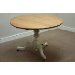 Circular light oak tilt top table, on turned painted pedestal with three splayed legs, D109cm,