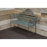 Wrought metal rustic grey garden bench with curved arms and shaped back,