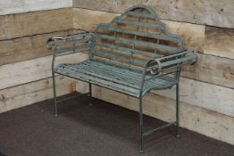Wrought metal rustic grey garden bench with curved arms and shaped back,