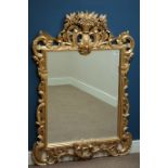 Ornate hand carved gilt wood wall mirror with flower basket pediment, bevelled glass, W92cm,