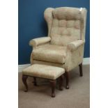 Wingback armchair with matching stool upholstered in floral fabric