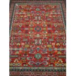 Large Persian design red ground rug, stylised and geometric decoration,