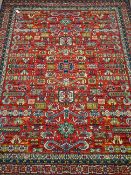 Large Persian design red ground rug, stylised and geometric decoration,