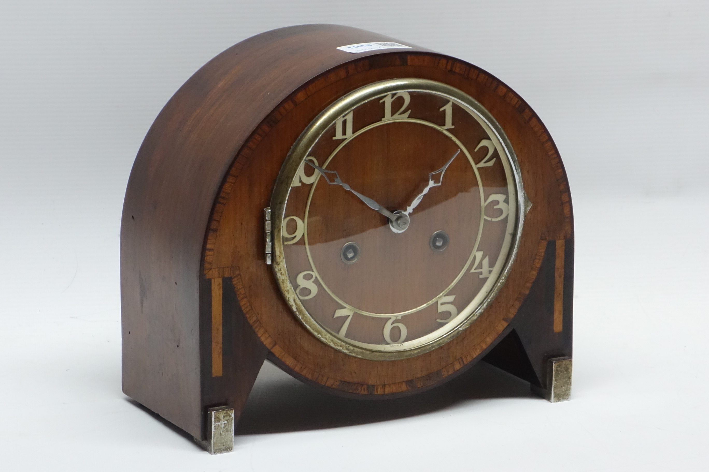 Art Deco period mantle clock in walnut inlaid banded cased with silvered feet,