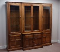 Ercol 'Mural' golden dawn finish elm three section wall unit with glazed and panelled doors, W223cm,