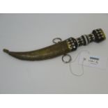 Egyptian dagger with ebonised handle and scale pattern curved blade in brass scabbard,