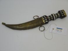 Egyptian dagger with ebonised handle and scale pattern curved blade in brass scabbard,