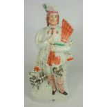 Large Victorian Staffordshire figure of Highlander with bagpipes and dog,