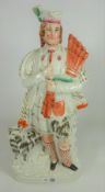 Large Victorian Staffordshire figure of Highlander with bagpipes and dog,