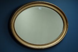 20th century oval gilt framed wall mirror with bevelled glass,