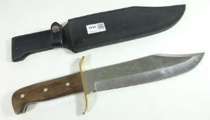 Bowie knife with wooden grip, brass guard and steel blade in leather sheath,