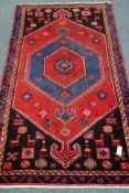 Persian Hamadan black ground rug, multiple lozenge, with stylised animal motifs,