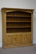 Large pine four tier bookcase with three panelled cupboards, W188cm, H212cm,