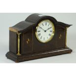 Early 20th century inlaid oak arched top mantle clock with brass columns and circular dial on brass