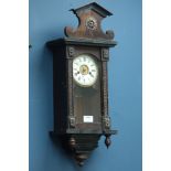 Late 19th century musical wall clock, stained architectural case with circular dial,