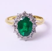 Gold emerald and brilliant cut diamond cluster ring, oval cut stone of 1.