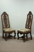 Pair oak Carolean style hall chairs, heavily carved with scrolls and foliage,
