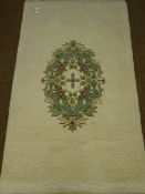 Indian washed woollen ivory and green ground rug,