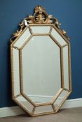 Octagonal wall mirror in gilt frame with sectional mirrored border and ornate pediment, W88cm,