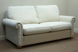 Two seat metal action sofa bed upholstered in cream fabric,