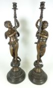 Pair of large cast metal candle holders in the form of Cherubs,