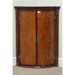 Early 19th century oak and mahogany banded wall hanging corner cupboard, bow front,