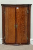Early 19th century oak and mahogany banded wall hanging corner cupboard, bow front,