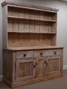 Traditional waxed pine dresser with twin shelf back and three drawers above three cupboards on a