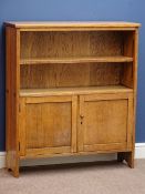 Oak vernacular bookcase, single adjustable shelf above double panelled cupboard,